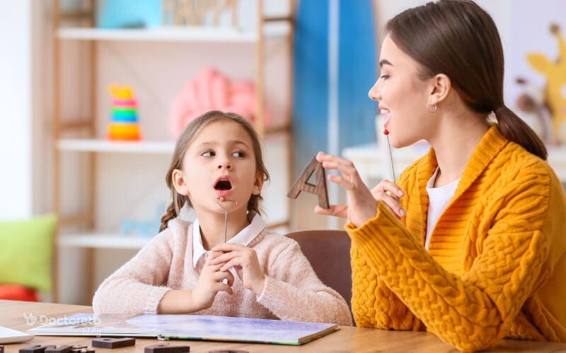 معلم لکنت زبان در حال آموزش کودک دارای لکنت